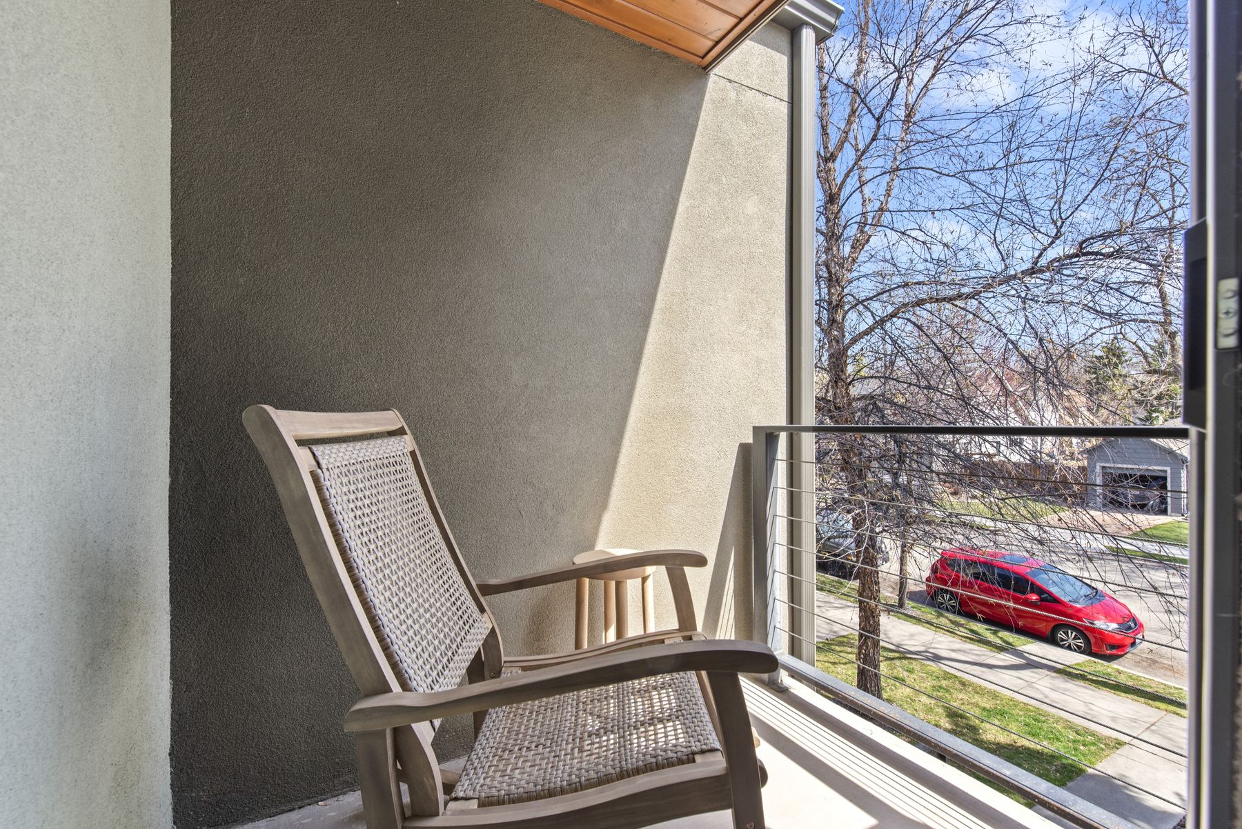 Private upstairs balcony overlooking a tree-lined North End Boise street